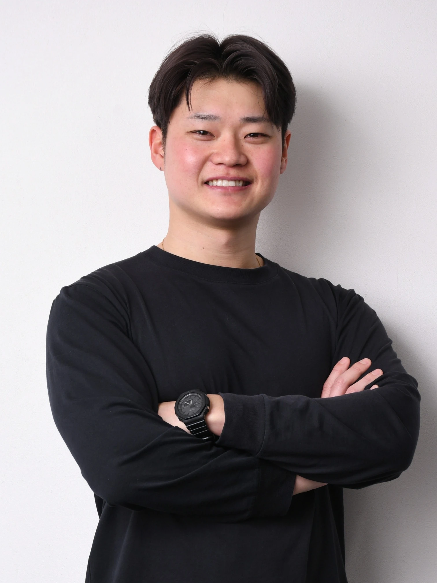 黒い長袖で腕を組み、正面を向くSun UP代表 坂本 駿